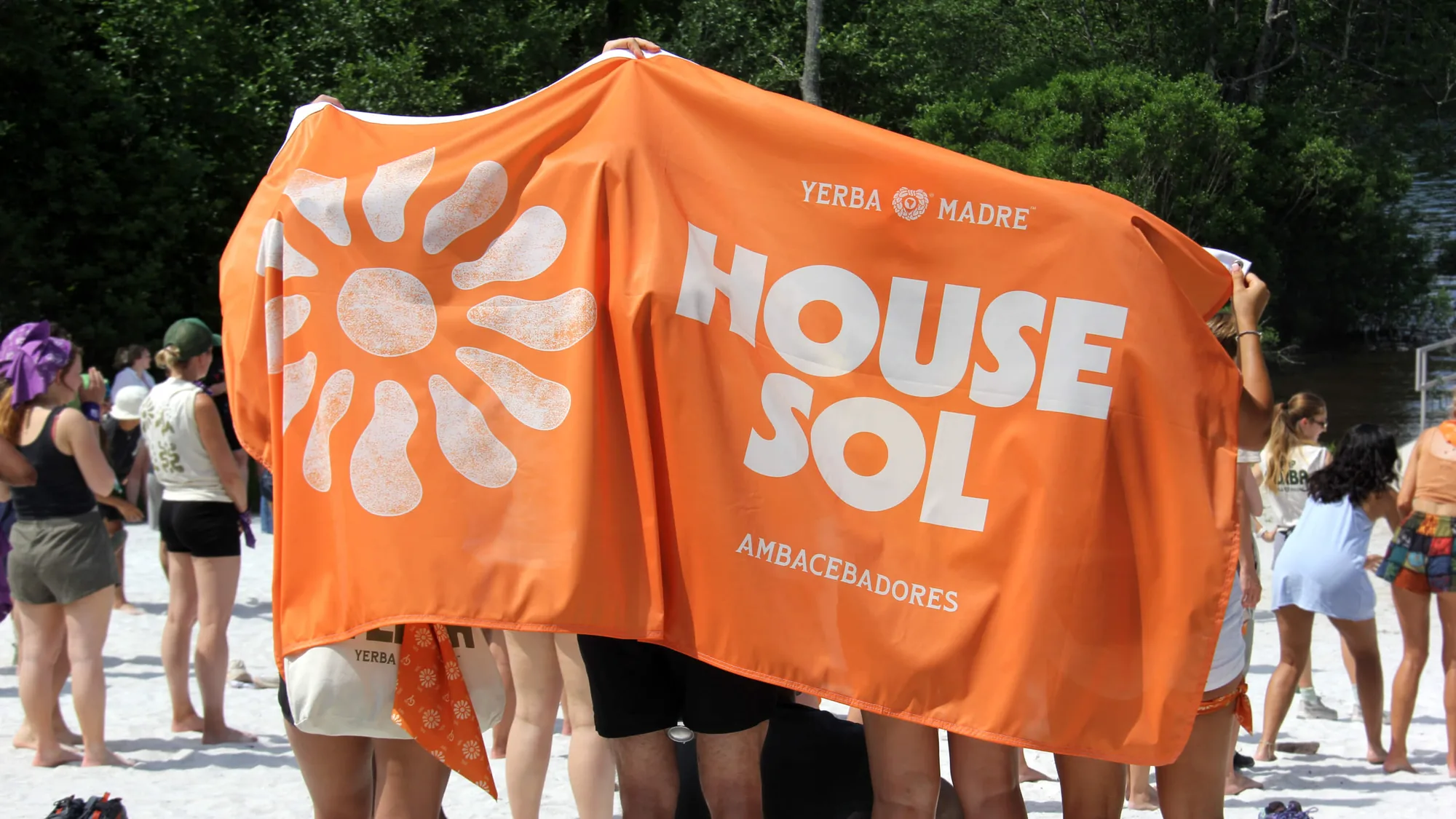 Campers holding up an orange House Sol banner