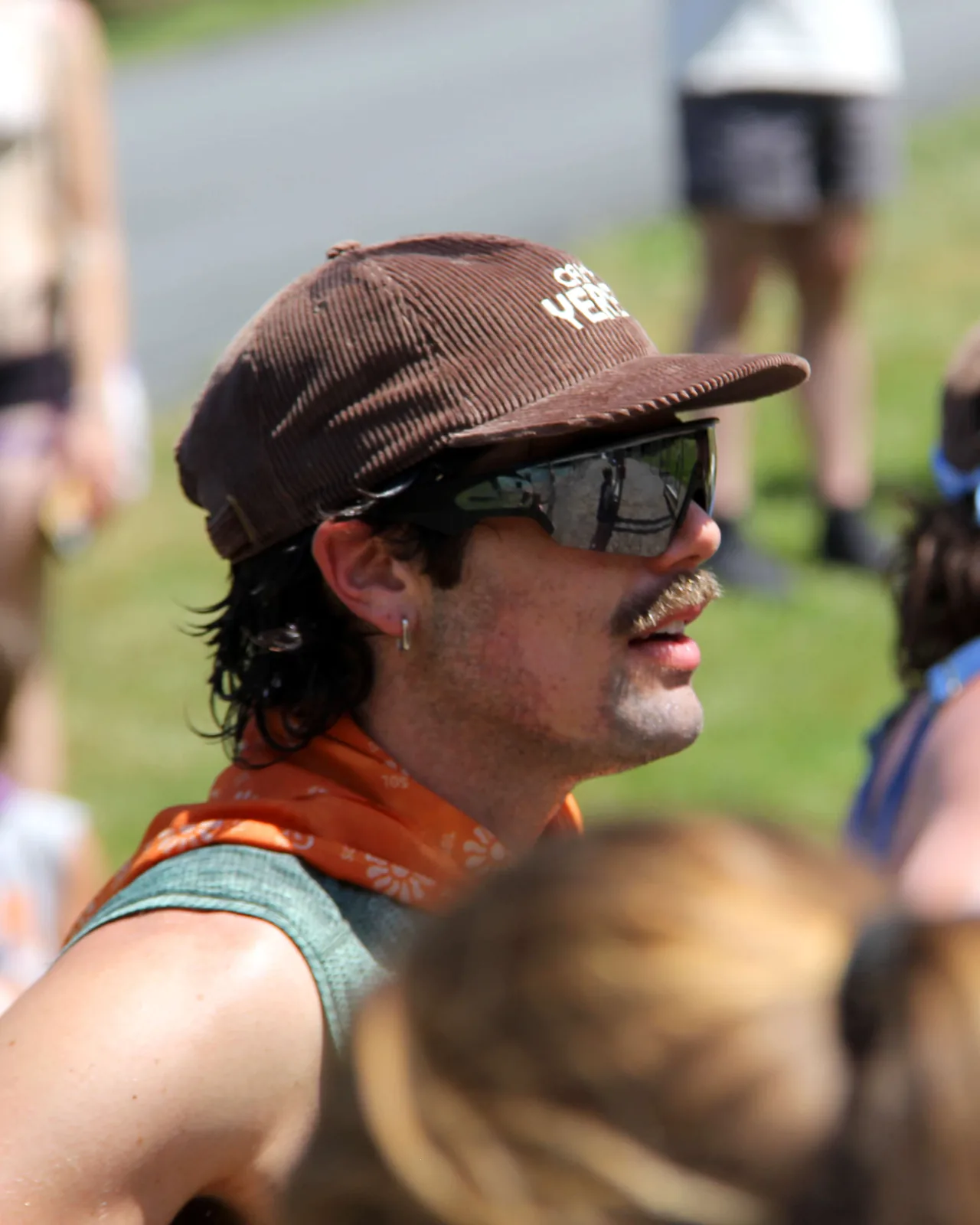 Camper in a brown Camp Yerba cap and an orange bandana