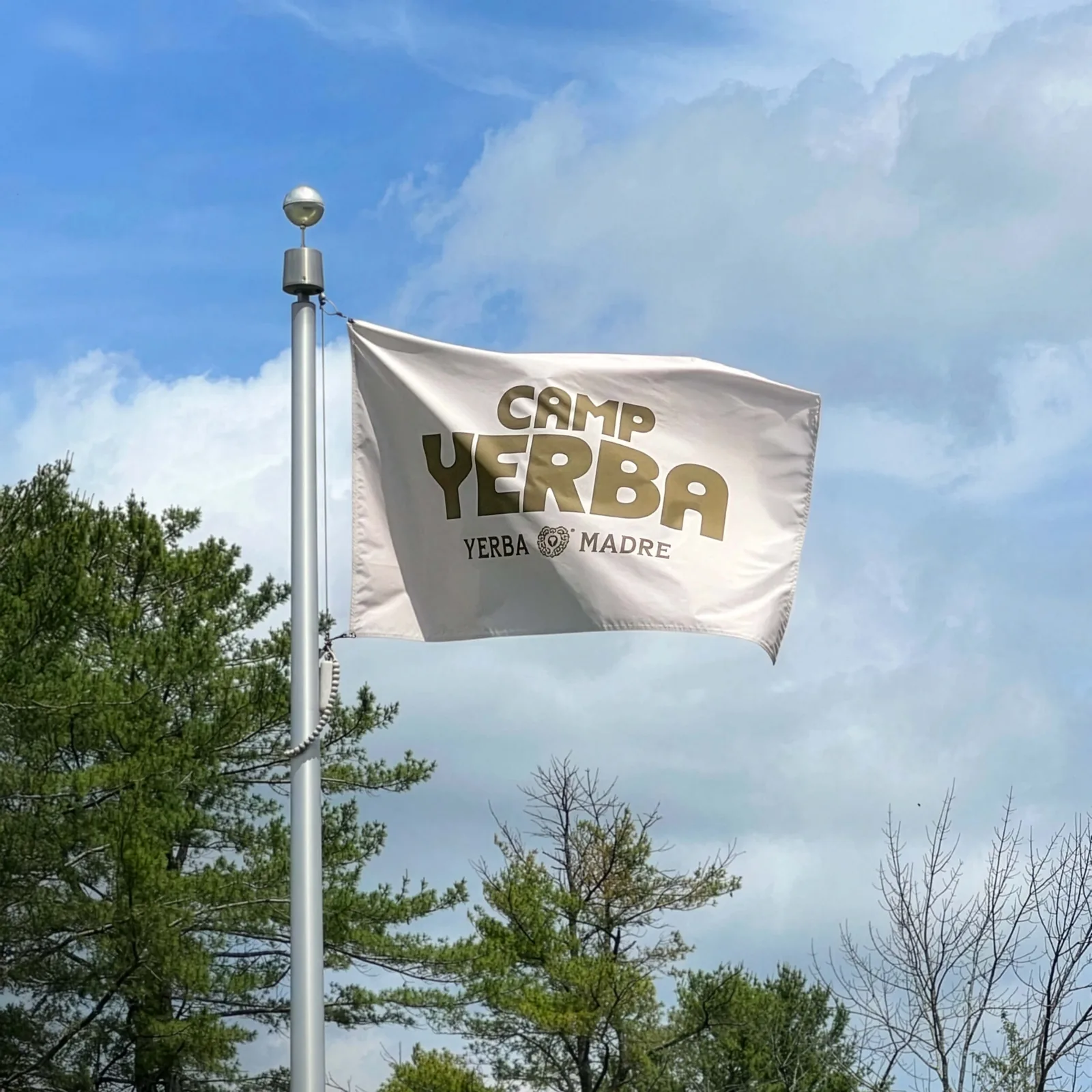 Camp Yerba flag flying on a pole against a blue sky