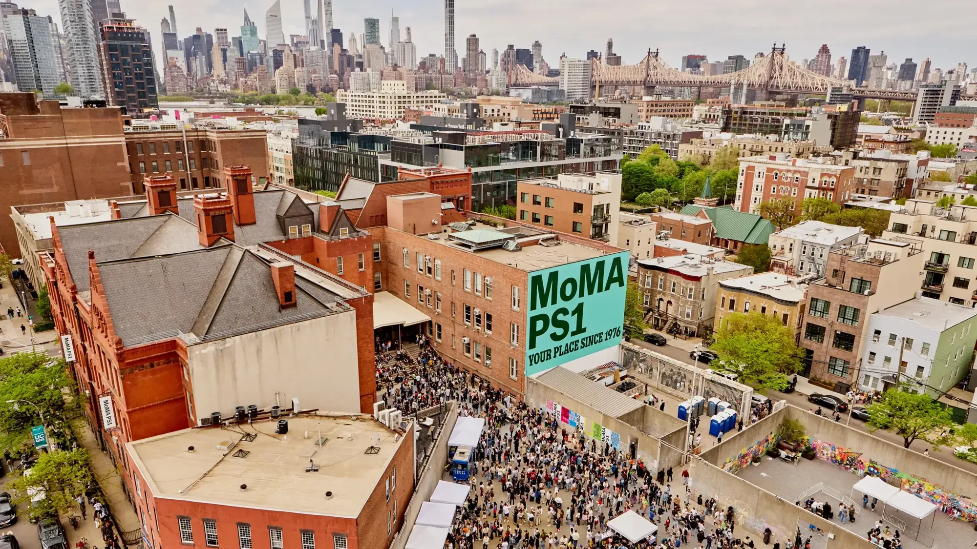 Aerial view of the MoMA PS1 courtyard packed for Warm Up, Manhattan skyline behind