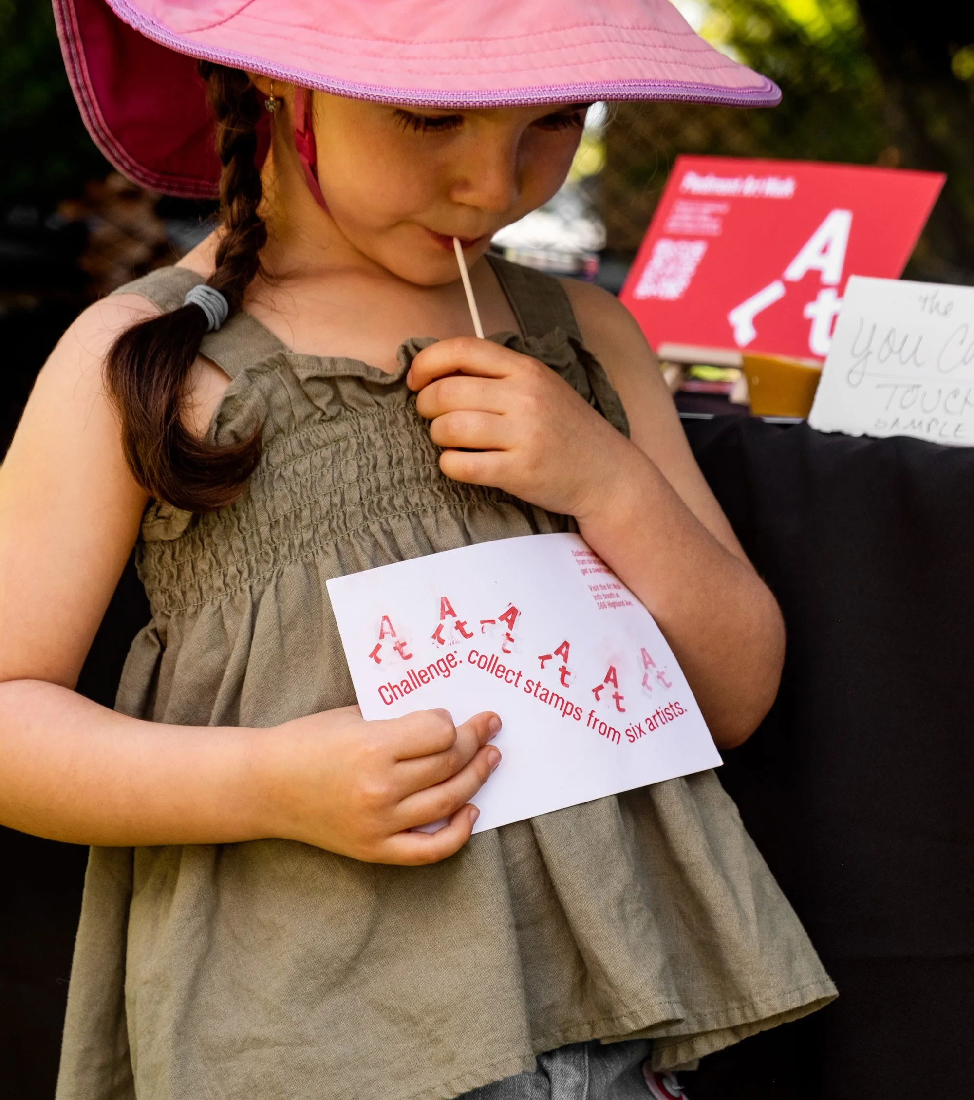 Child holding the Piedmont Art Walk stamp card