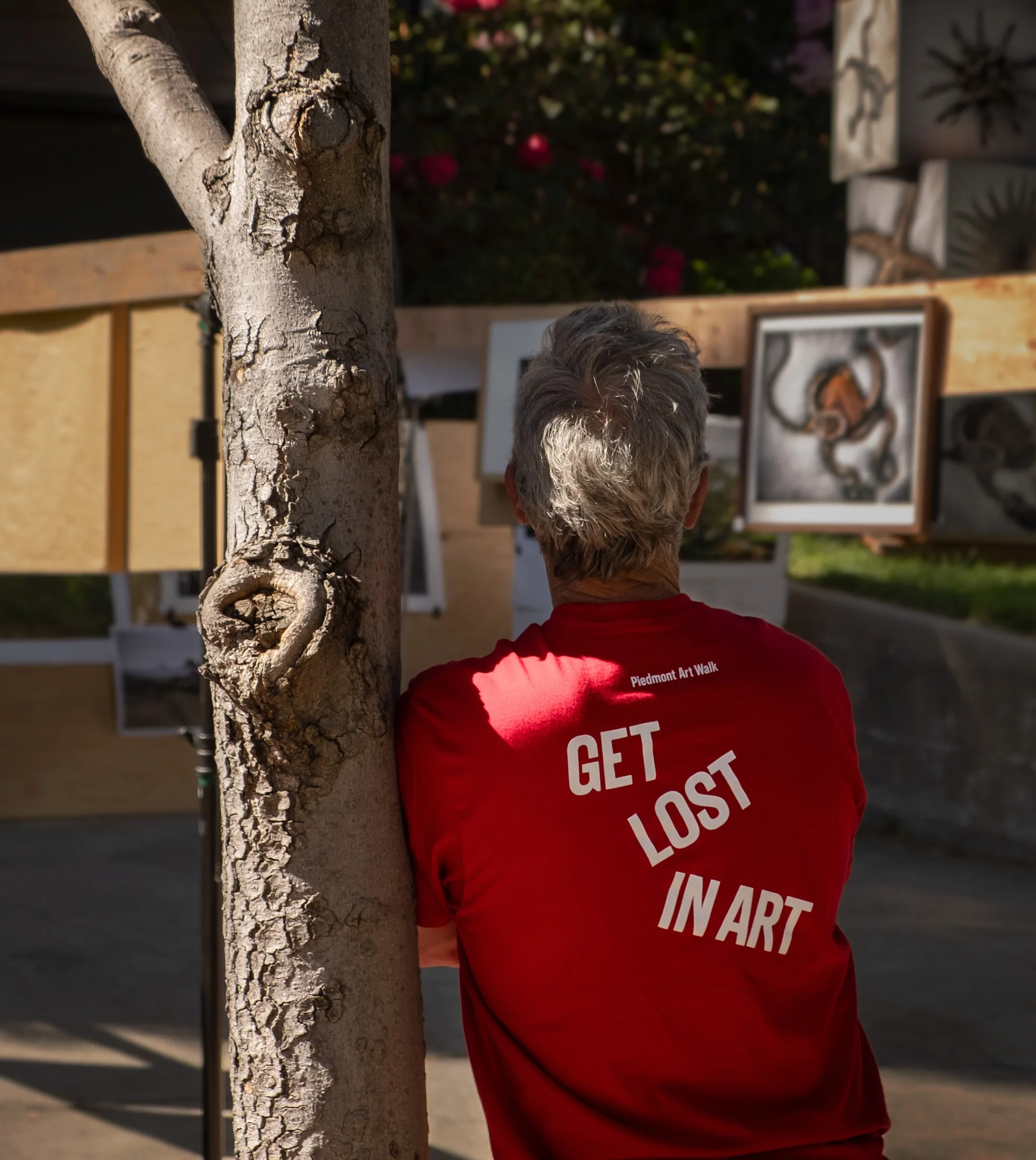 Volunteer in a Get lost in art tee at an outdoor exhibit