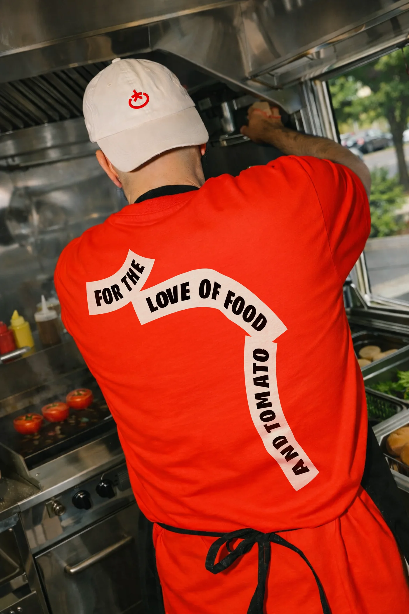 Cook in a red Toomato T-shirt with the ribbon print on the back
