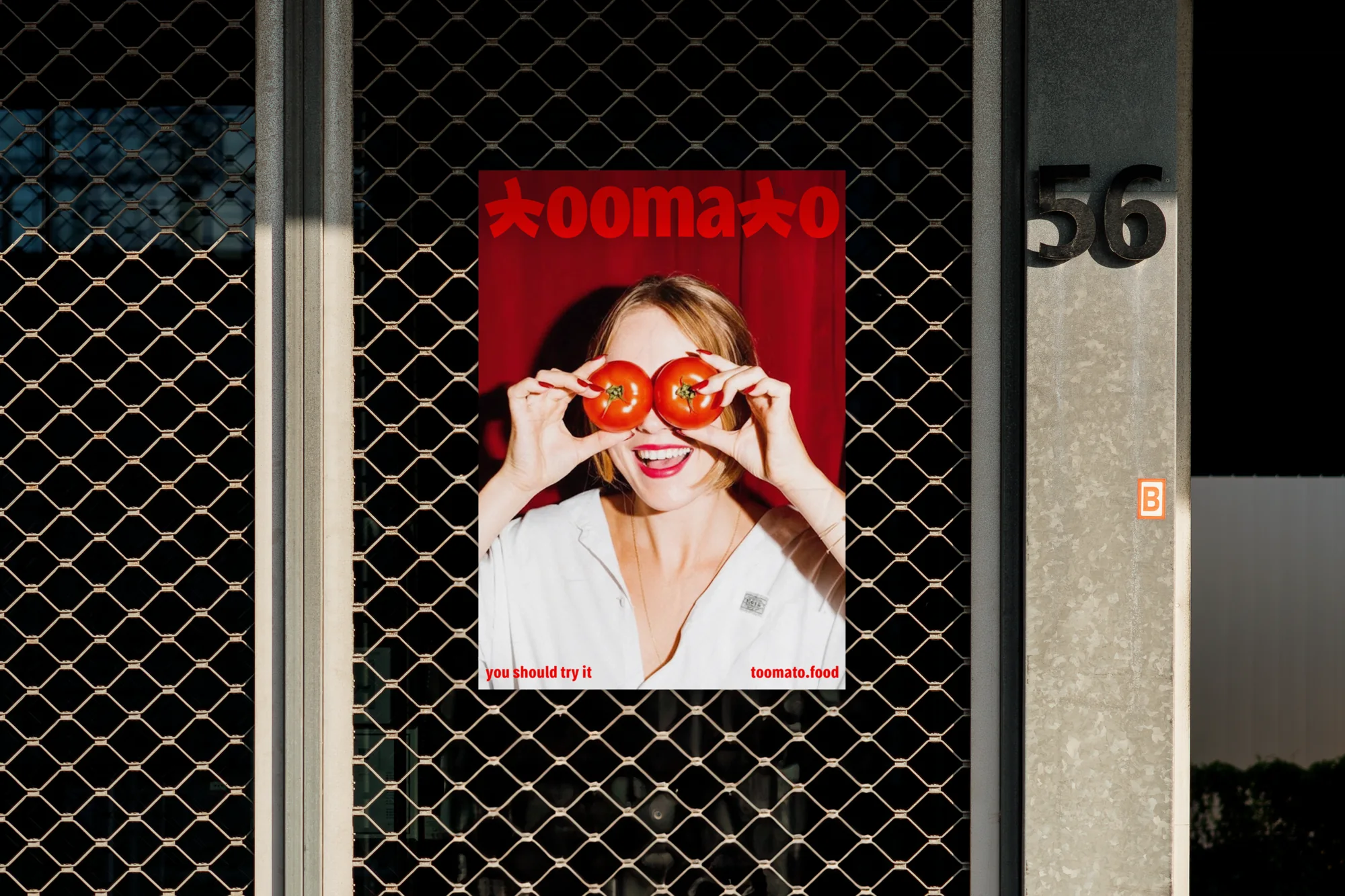 Toomato poster in a shop window: a woman holding tomatoes over her eyes