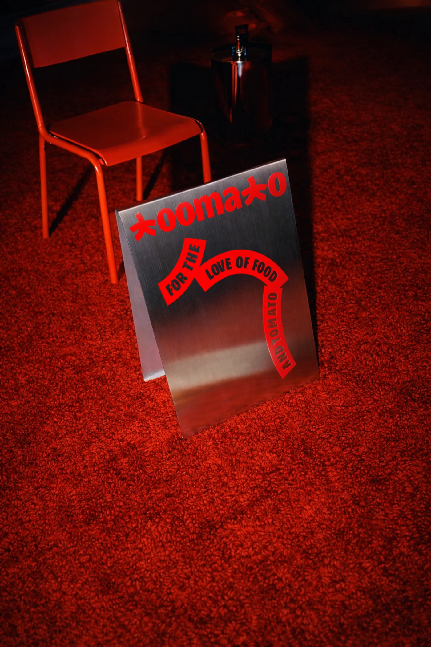 Brushed metal Toomato sign on a red carpet