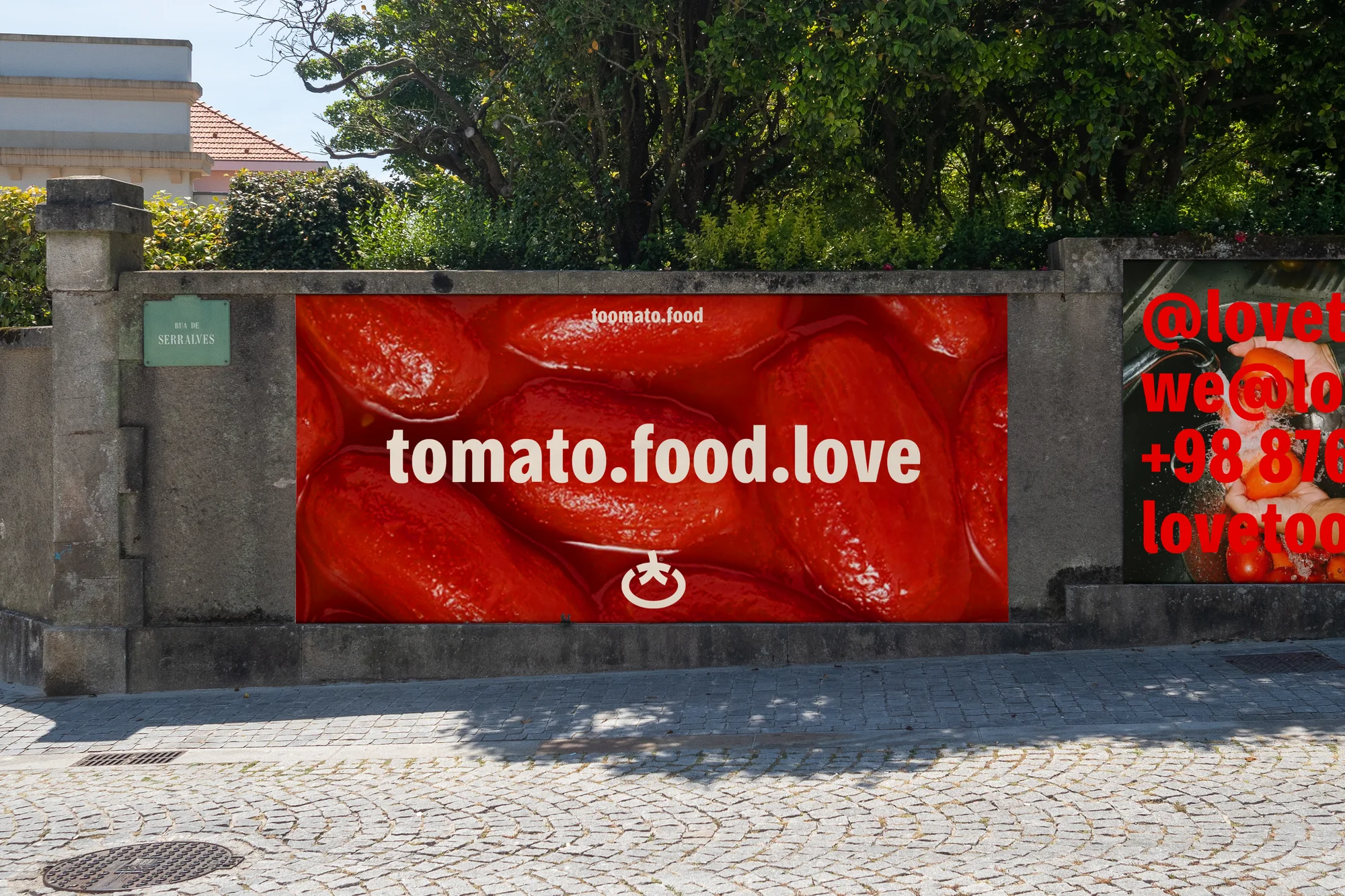Toomato billboard on a stone wall: tomato.food.love over peeled tomatoes