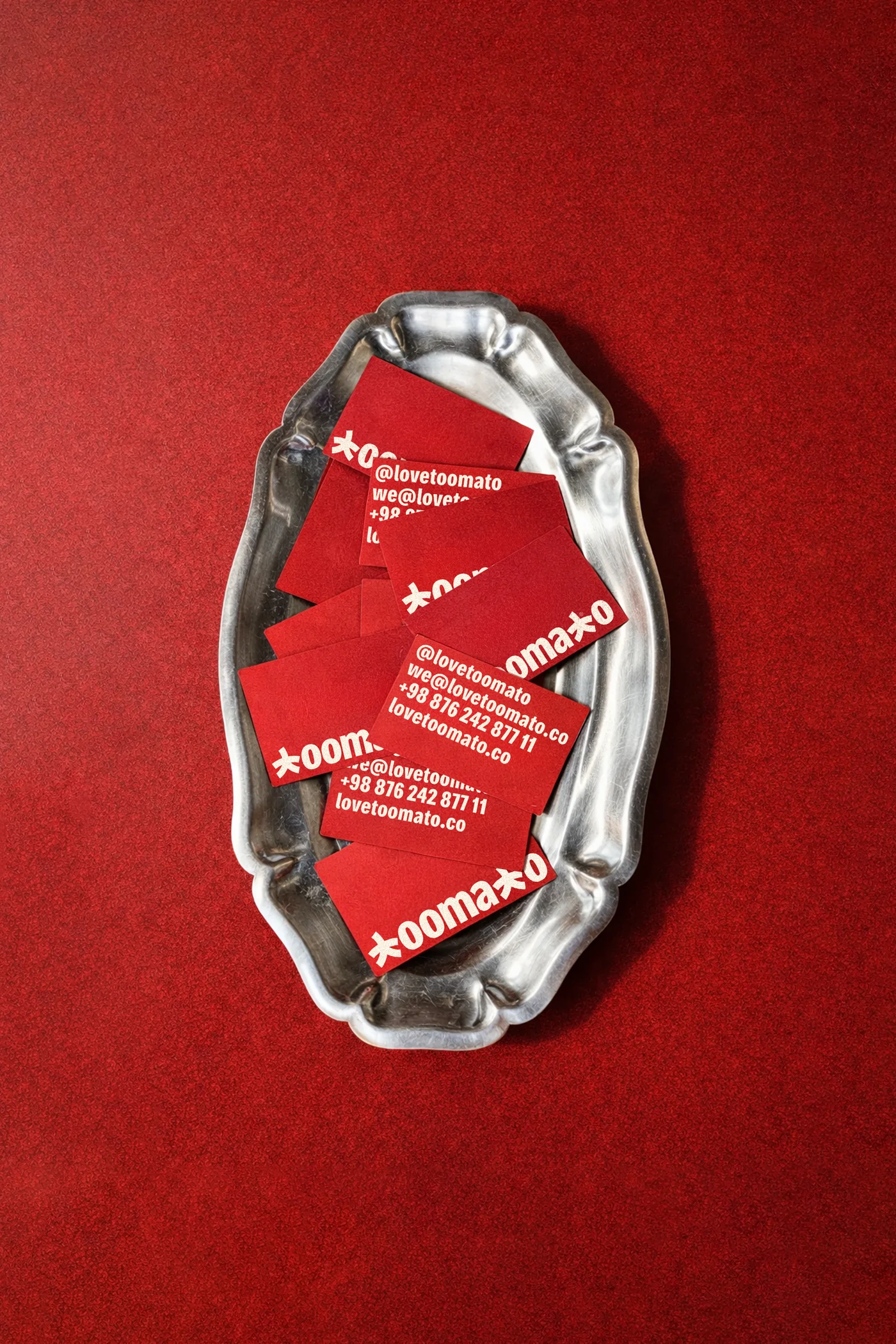 Red Toomato business cards on a silver tray