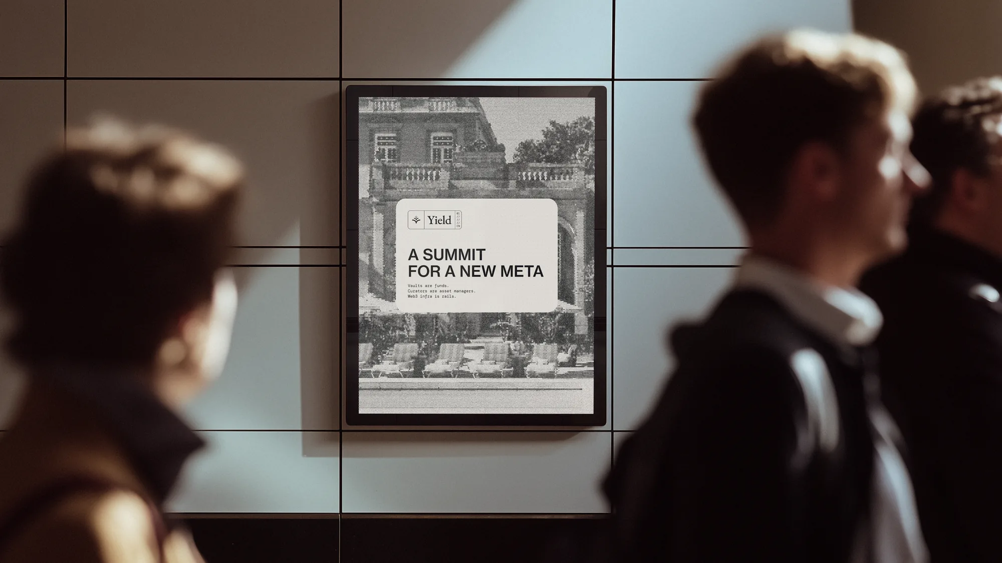Framed Yield poster of the Cannes venue on a wall as people walk past